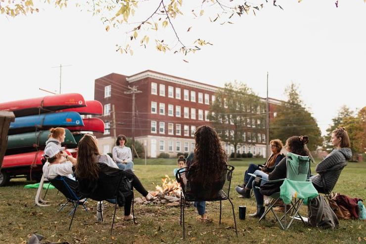 白天，九名电子游艺信誉排行的学生围坐在户外的火堆旁
